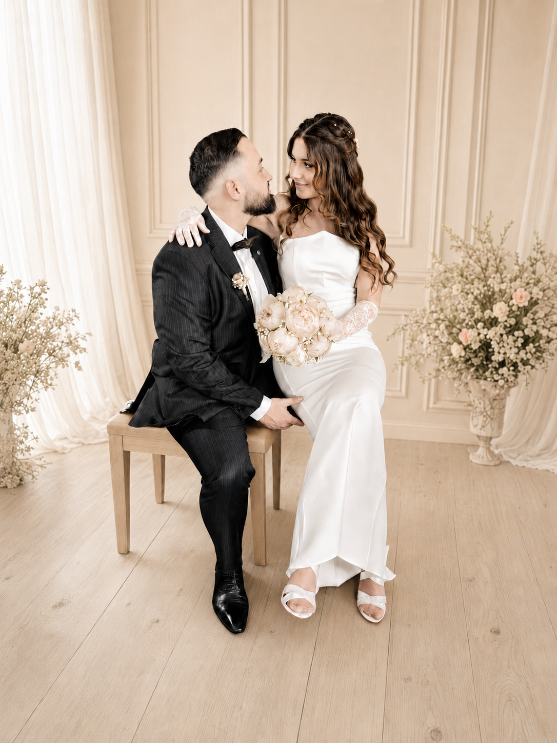 Ilayda und Tarkan im Hochzeitsoutfit auf einer Holzbank mit Brautstrauss